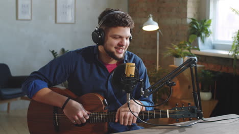 Joyous-Musician-with-Guitar-Speaking-on-Camera-in-Recording-Studio